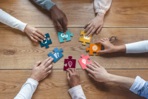 people fitting together puzzle pieces signifying their contributed work